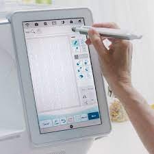 Image of a person using the touch screen on a sewing machine.